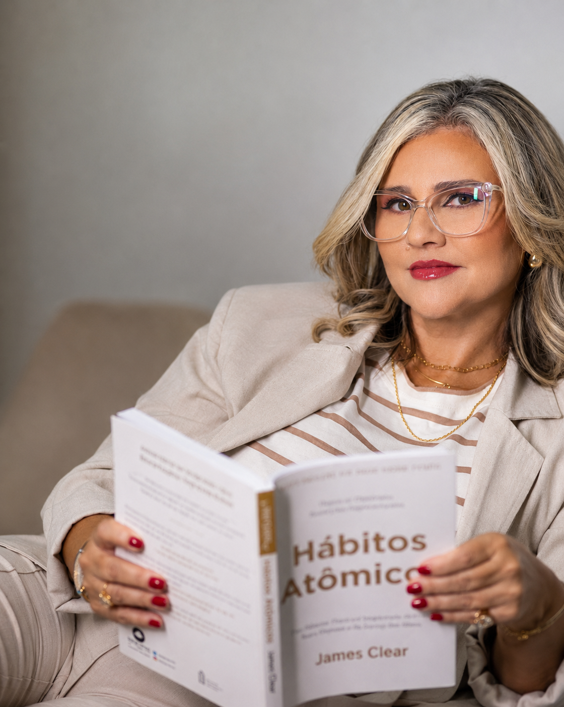 Adriana Gomes, psicóloga, segurando um livro em seu consultório